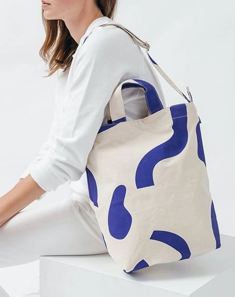 A perfect everyday tote in durable recycled cotton canvas duck. Two handles and 40 in. adjustable strap, to carry in hand or over shoulder. **** 16 in. H x 10 in. W x 5.5 in. D. Matte silver hardware.