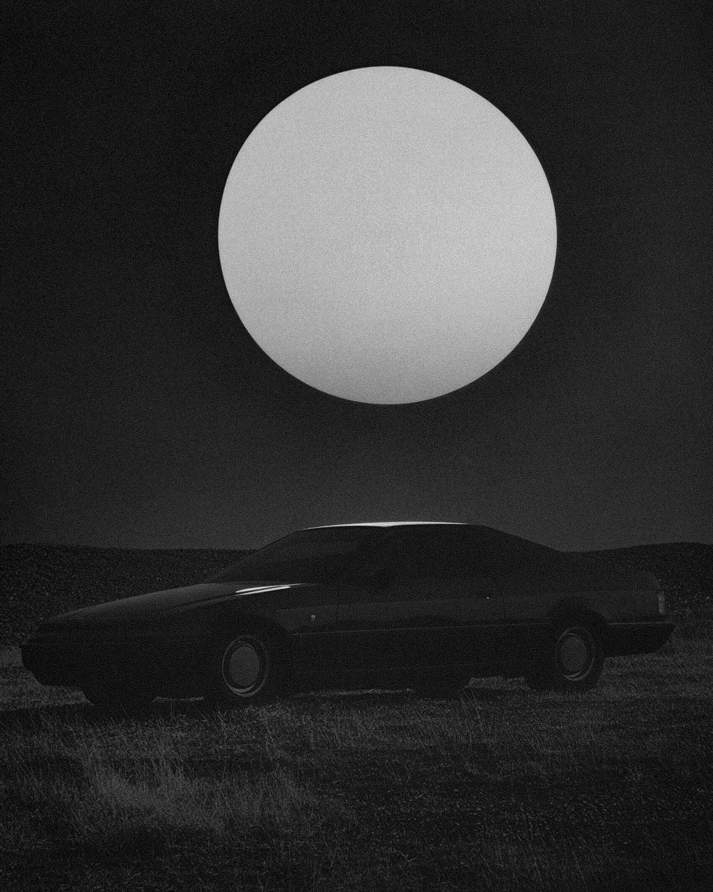 A lone 1980s car under the super moon