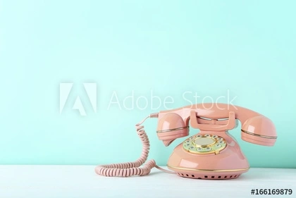 Pink retro telephone on white wooden table