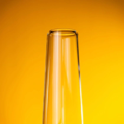 A close-up image of the mouthpiece of our bong's tube glowing beautifully under light, set against a bright, yellow background. This is the first part of our four-part teaser series emphasizing our product's quality and craftsmanship.