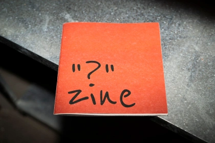 Shot of a zine on a metal shelf with harsh light