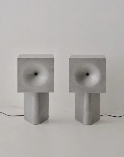 Two metal speakers on a white backdrop