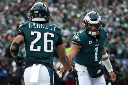 PHILADELPHIA, PENNSYLVANIA - JANUARY 26: Jalen Hurts #1 of the Philadelphia Eagles celebrates with teammate Saquon Barkley #26 after a 4 yard touchdown against the Washington Commanders during the first quarter in the NFC Championship Game at Lincoln Financial Field on January 26, 2025 in Philadelphia, Pennsylvania.  (Photo by Emilee Chinn/Getty Images)